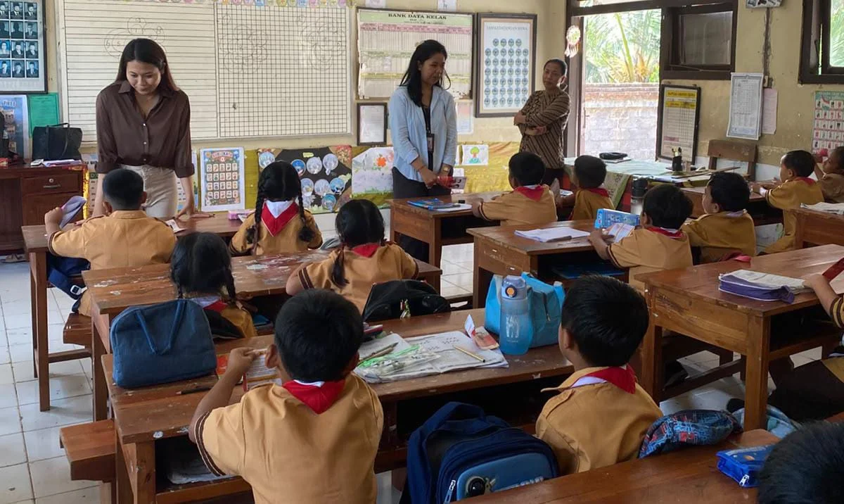 Foto: Karyawan PT BPR Bank Daerah Gianyar saat menyapa para siswa dan siswi di SDN 1, Bakbakan.